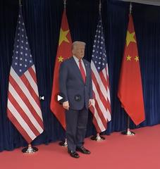 President Trump before the flags of the United States and China