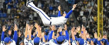 Yokohama DeNA BayStars players celebrate by tossing a member of the team into the air