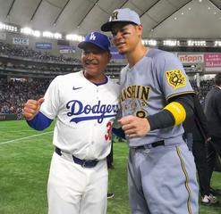 Hanshin's Teruaki Sato, right, with Los Angeles Dodgers manager Dave Roberts, in a file photo taken at the Tokyo Dome in March 2025