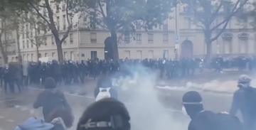 Riot police and protesters in a haze of tear gas on a Paris street